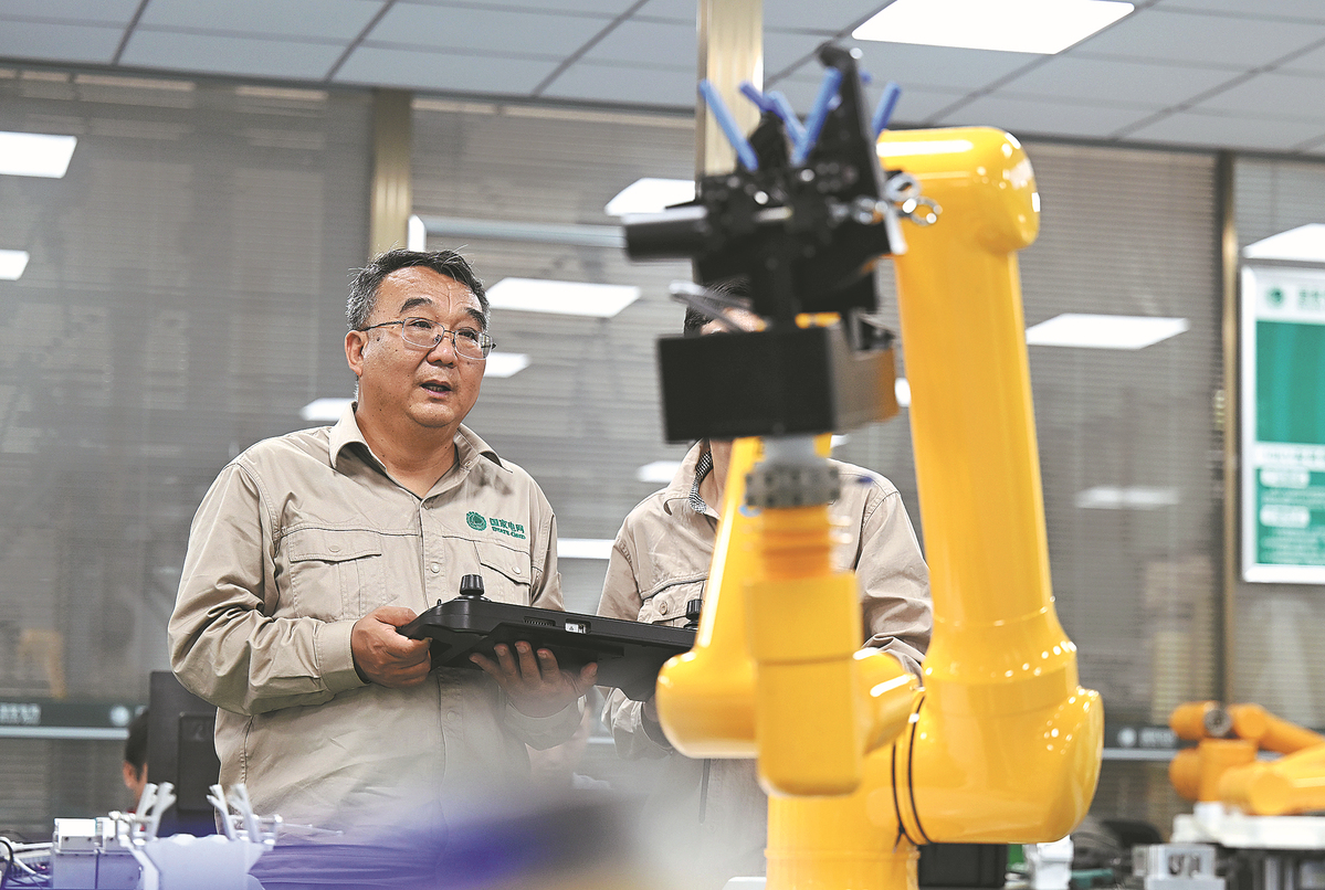 Zhang Liming dhe një bashkëpunëtor shpërndajnë një robot që është në gjendje të kryejë punë mirëmbajtjeje në rrjetin elektrik në Tianjin muajin e kaluar.