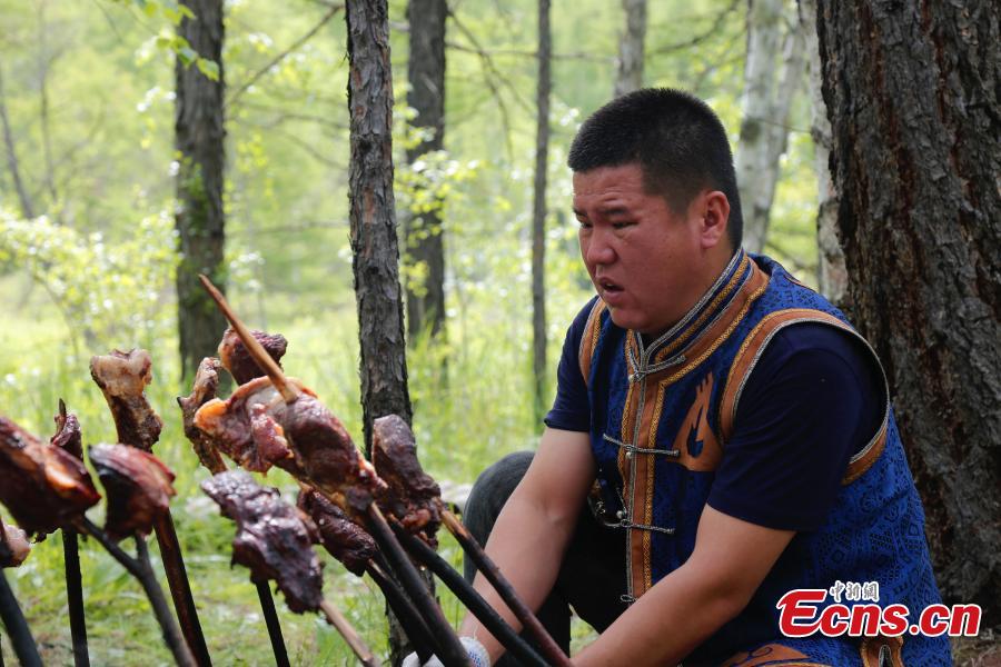 Ένας Οροτσέν ψήνει για τους τουρίστες στο 33ο Φεστιβάλ Φωτιάς των Οροτσέν στο Αυτόνομο Λάβαρο Οροτσέν στην Αυτόνομη Περιοχή της Εσωτερικής Μογγολίας, στις 18 Ιουνίου 2023 (Photo: China News Service/Zhang Wei)