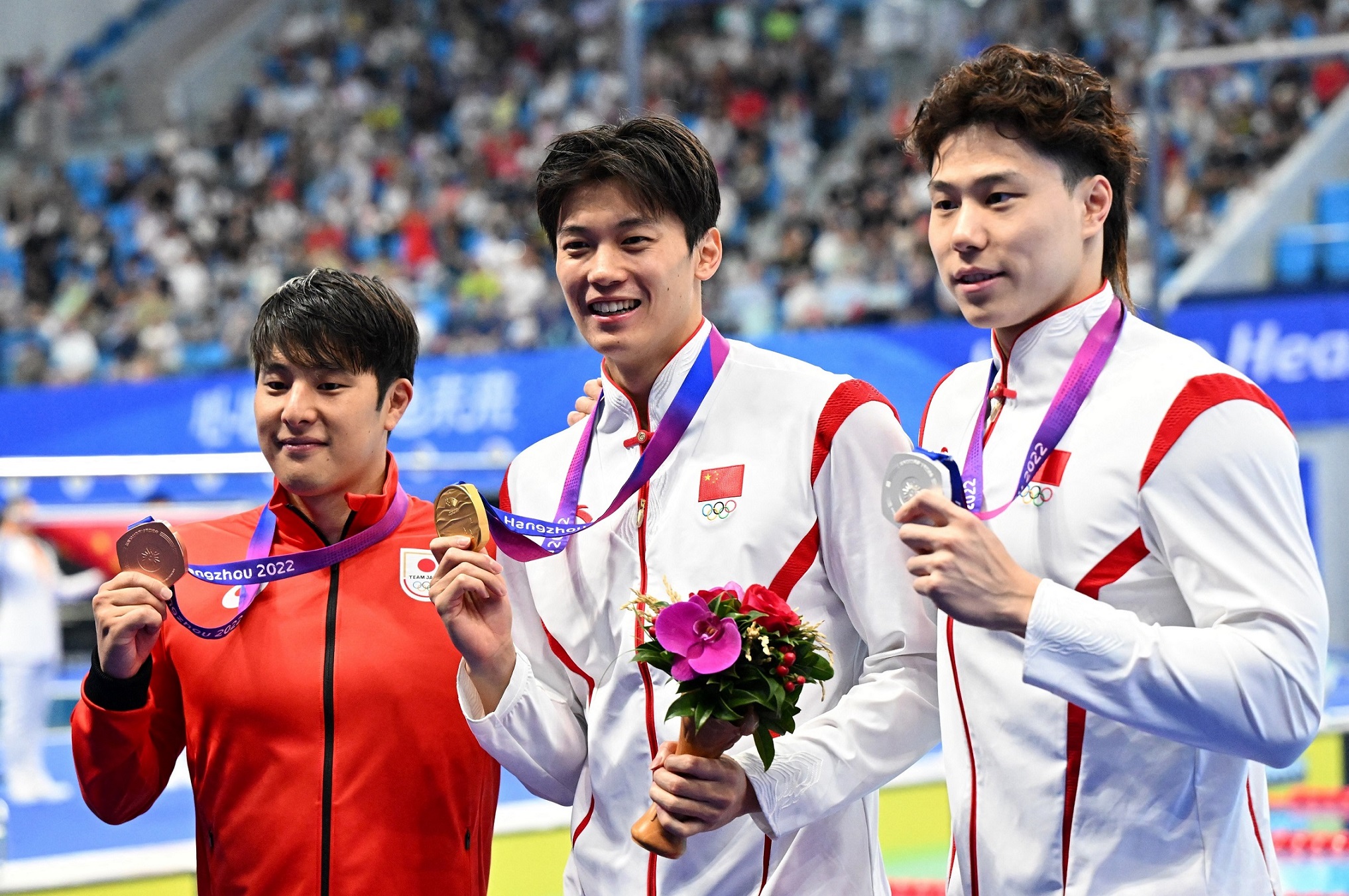 Wang Shun (centru) și Qin Haiyang (dreapta) au luat medalia de aur și respectiv de argint la proba de 200 metri mixt masculin a Jocurilor Asiatice de la Hangzhou. (24 septembrie 2023) (IC photo)