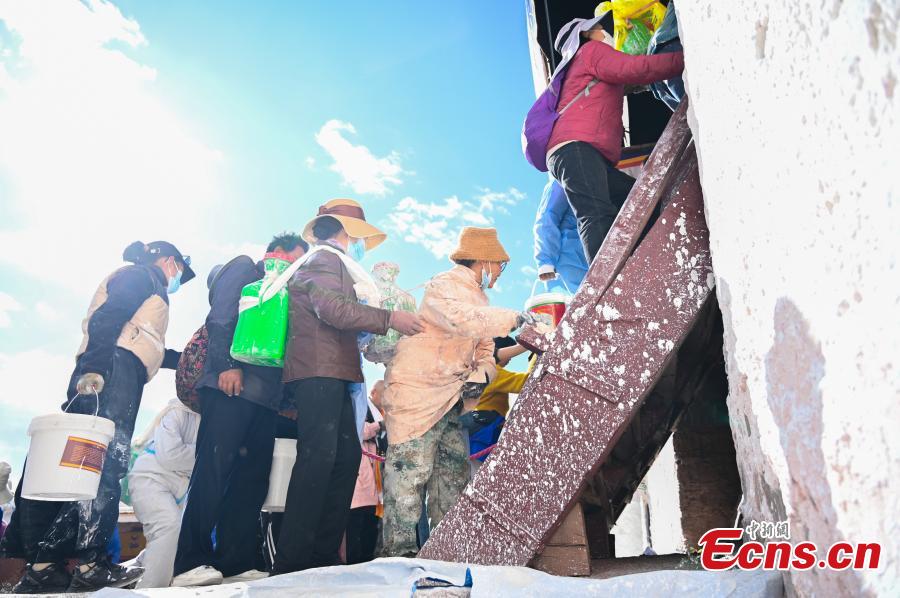 Οι ντόπιοι κάνουν ουρά για να βάψουν τους τοίχους του Παλατιού Ποτάλα κατά τη διάρκεια ενός ετήσιου έργου ανακαίνισης στη Λάσα, στην Αυτόνομη Περιφέρεια του Θιβέτ της νοτιοδυτικής Κίνας, στις 18 Οκτωβρίου 2023. (Φωτογραφία: China News Service/Zhao Lang)