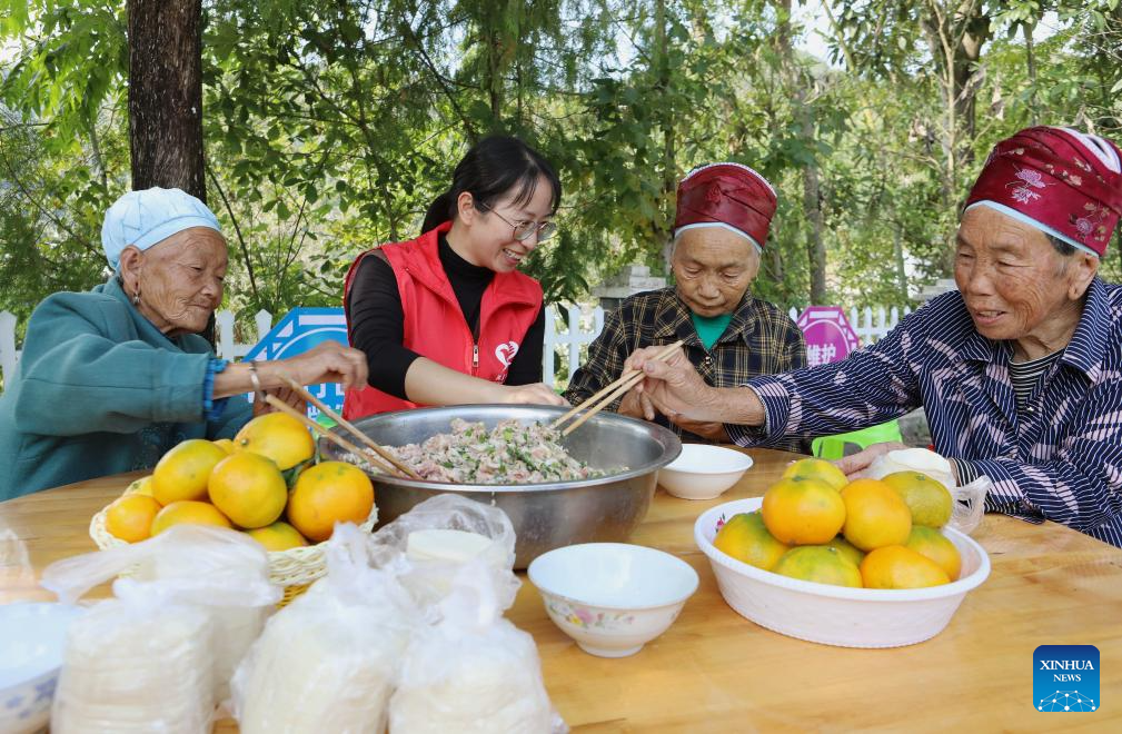 Μια εθελόντρια και ηλικιωμένες φτιάχνουν μαζί κουλουράκια σε μια δραστηριότητα του Φεστιβάλ Τσονγκγιάνγκ στο χωριό Γκαομπέι της πόλης Γκανσί του Τσιμπίνγκ, στην αυτόνομη νομαρχία Τσιανντονγκνάν Μιάο και Ντονγκ στην επαρχία Γκουιτζόου της νοτιοδυτικής Κίνας, 22 Οκτωβρίου 2023.