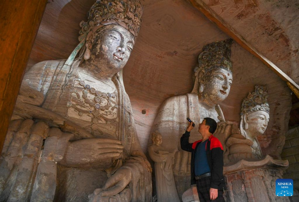 Ένας εθελοντής πραγματοποιεί μια περιοδεία επιθεώρησης σε ένα χώρο προστασίας πολιτιστικών κειμηλίων των σκαλισμάτων των Βράχων Νταζού στο Τσονγκτσίνγκ της νοτιοδυτικής Κίνας στις 31 Οκτωβρίου 2023.