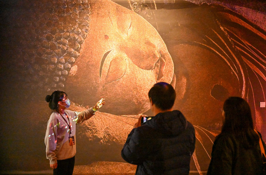Ξεναγός στην έκθεση με θέμα τον πολιτισμό Ντουνχουάνγκ στο Μουσείο Ψηφιακής Τέχνης στο Τιεντζίν στη βόρεια Κίνα, 28 Νοεμβρίου 2023. Η έκθεση θα διαρκέσει μέχρι τον Μάρτιο του 2024. [Φωτογραφία/Xinhua]