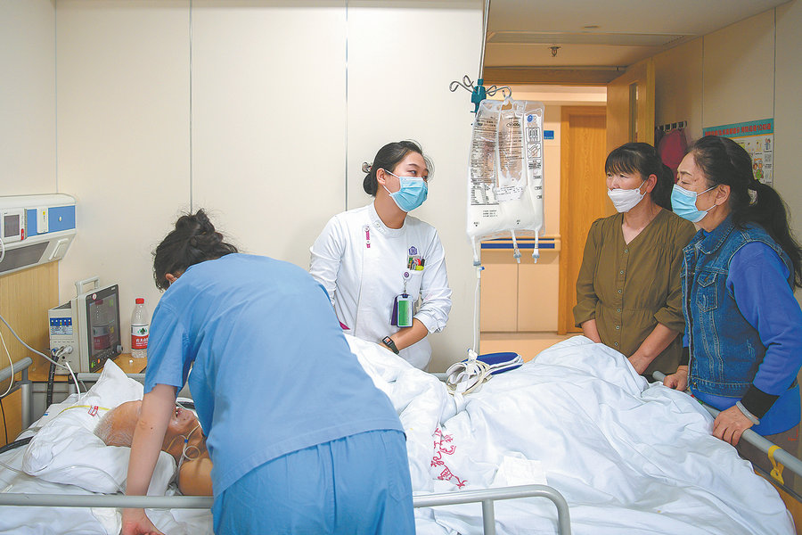 Η Τζανγκ Σινγιέν, γιατρός από το τμήμα του κέντρου παρηγορητικών του νοσοκομείου Τσινγκχούα Τσανγκούνγκ του Πεκίνου (στο πόδι του κρεβατιού), προτείνει μια πορεία θεραπείας στο νοσοκομείο Tiantongyuan TCM στην περιοχή Τσανγκπίνγκ του Πεκίνου. [Φωτογραφία από Pan Songgang/Sun Ren/For China Daily]