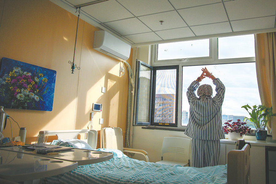 Απολαμβάνοντας το ηλιοβασίλεμα, μια ασθενής τεντώνεται στο δωμάτιό της στο νοσοκομείο Χαϊντιέν του Πεκίνου. [Φωτογραφία από Pan Songgang/Sun Ren/For China Daily]