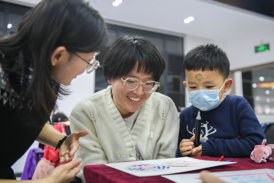 Η εκπαιδεύτρια Γουάνγκ Φέι (πρώτος αριστερά) διδάσκει ζωγραφική κατά τη διάρκεια ενός μαθήματος νυχτερινού σχολείου στην περιοχή Χονγκσάν της Γουχάν, στην επαρχία Χουμπέι της Κεντρικής Κίνας, 11 Ιανουαρίου 2024. [Φωτογραφία/Xinhua]