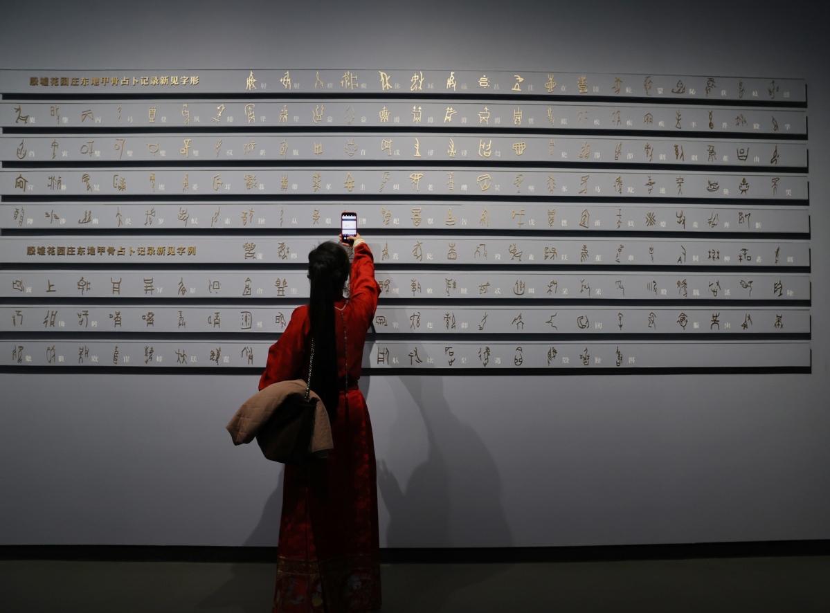 Επισκέπτρια φωτογραφίζει τους χαρακτήρες που βρέθηκαν πάνω σε κελύφη και που εκτίθενται στο νέο κτίριο του Μουσείου Γινσού, το οποίο άνοιξε για το κοινό τη Δευτέρα, στην Ανγιάνγκ, επαρχία Χενάν. JIANG DONG/CHINA DAILY