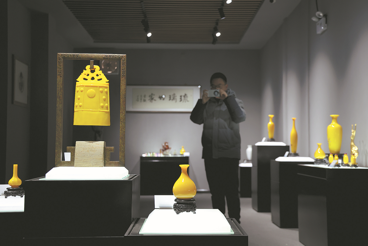 Επισκέπτης τραβά φωτογραφίες μιας γυάλινης καμπάνας σε ένα μουσείο γυαλιού στο Ζιμπό στις 23 Ιανουαρίου. [Φωτογραφία Wang Jing/China Daily]