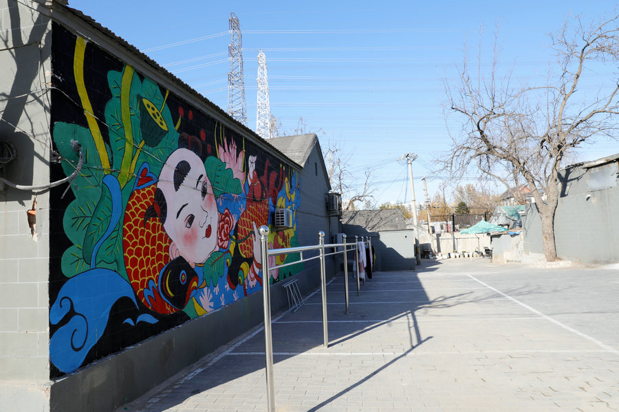 Οι καλλιτέχνες από την Κεντρική Ακαδημία Καλών Τεχνών και οι κάτοικοι του Μπανμπιντιέν φτιάχνουν μαζί τοιχογραφίες. [Φωτογραφία από την China Daily]