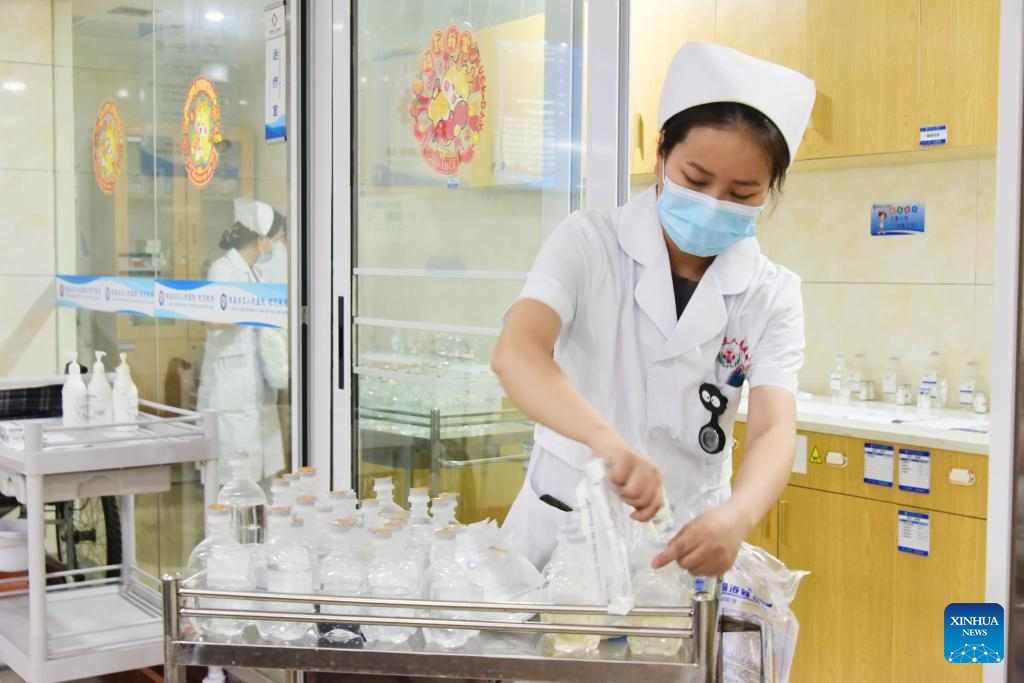 Μια νοσοκόμα προετοιμάζει φάρμακα για ασθενείς στο τμήμα νοσηλείας ενός νοσοκομείου στο Τσανγκντέ, στην επαρχία Χουνάν της κεντρικής Κίνας, 12 Μαΐου 2024. (Φωτογραφία Bai Yipu/Xinhua)