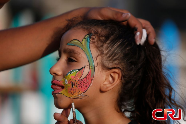 قطاع غزة: فنان يرسم أشكالا فنية على وجوه الأطفال